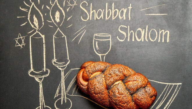 chalkboard that says "shabbat shalom" with challah