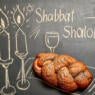 chalkboard that says "shabbat shalom" with challah