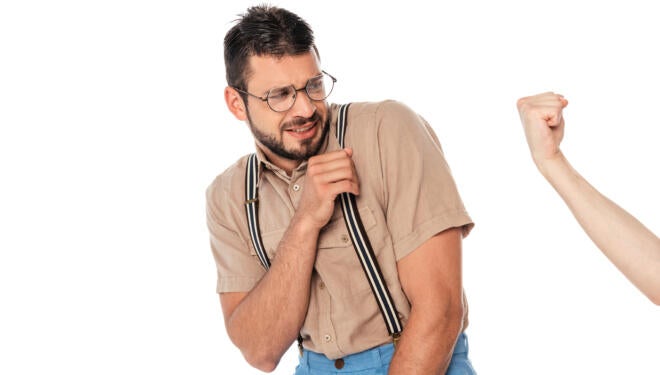 Man cringing in front of someone else's fist.