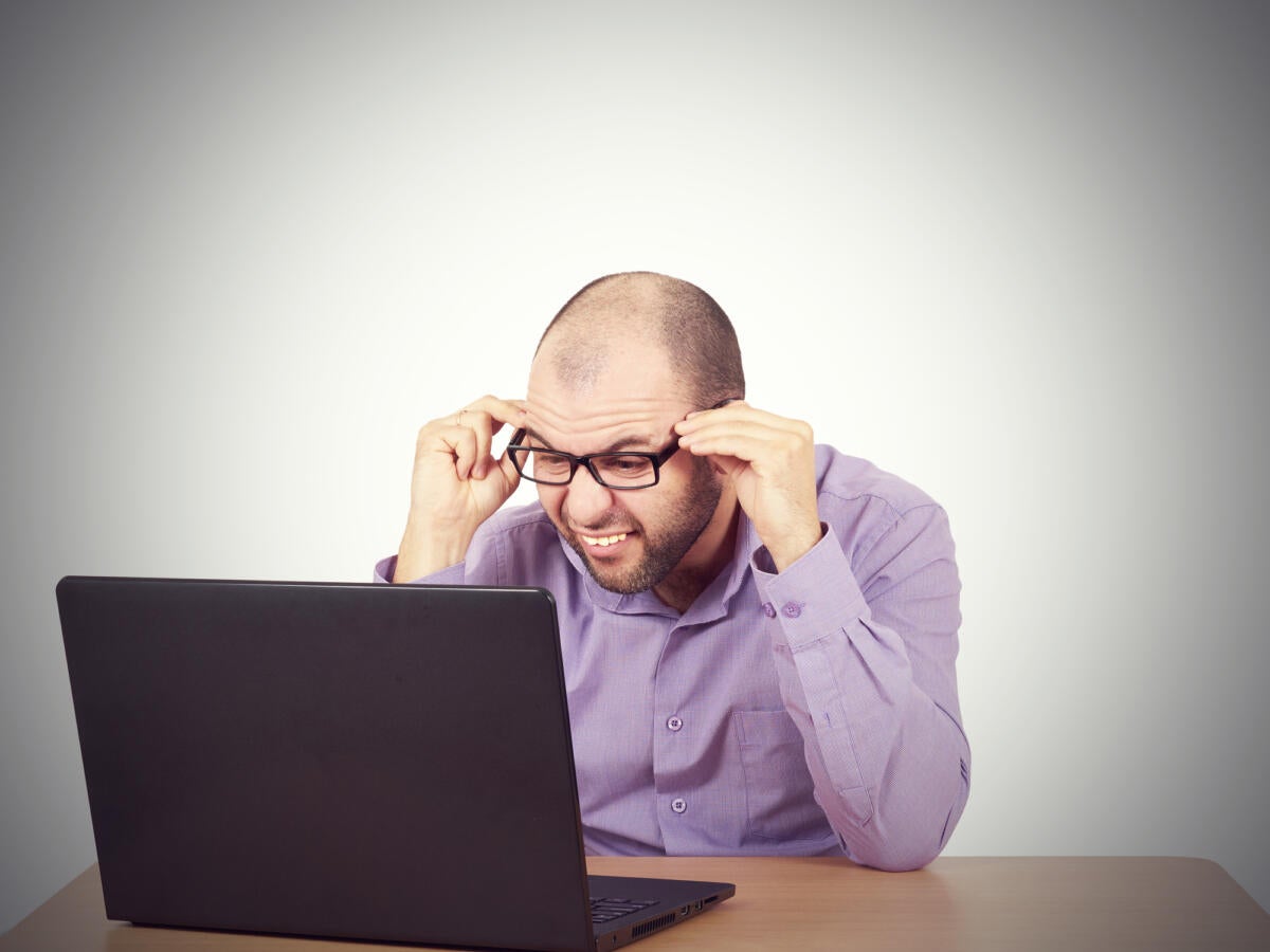 man looking in confusion at his computer
