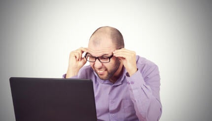 man looking in confusion at his computer