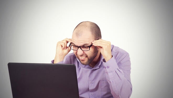 man looking in confusion at his computer