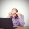 man looking in confusion at his computer