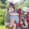 Father carrying two sleeping children.